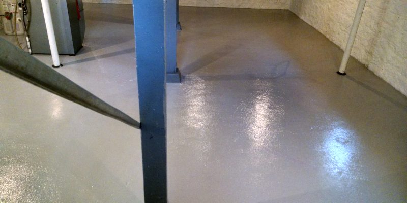 unfinished basement painted gray floor and waterproofed walls clean